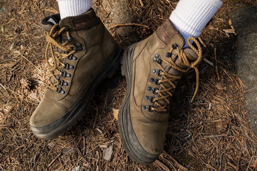 Botas de montañero marrones en sendero forestal